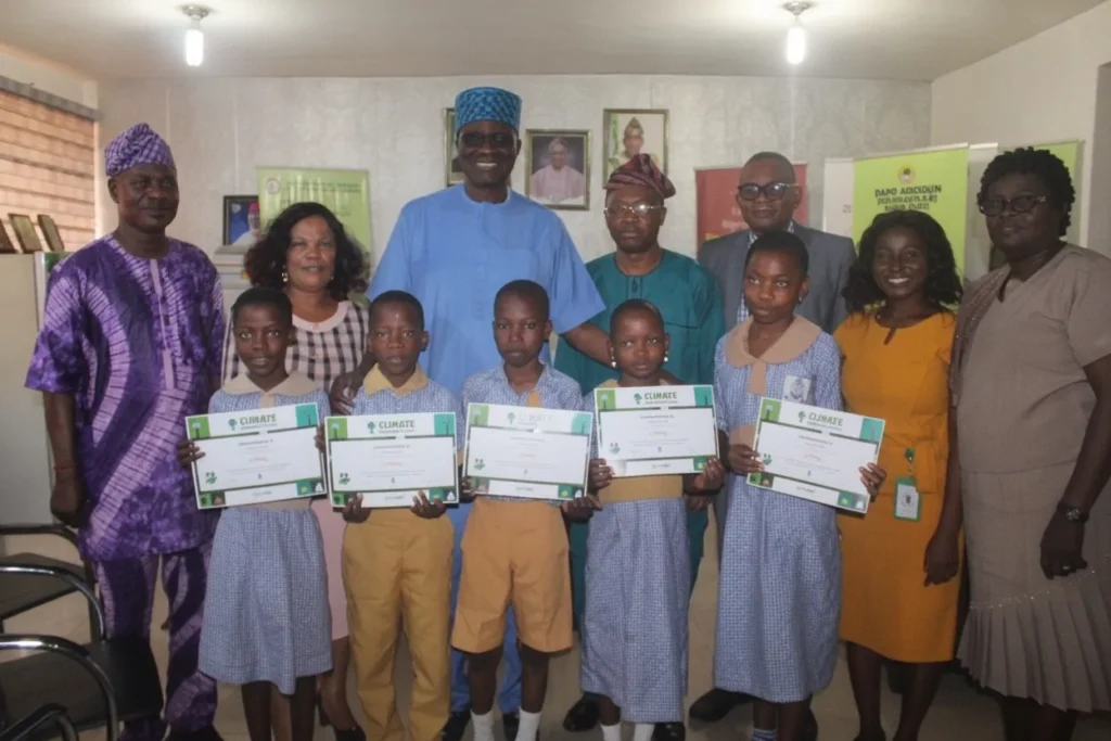 Young gardeners holding their certificates with teachers