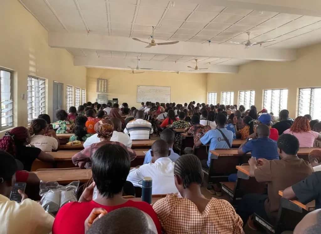Students seated in a large hall for a session